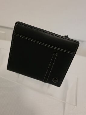 Tumi Black Leather Bi-Fold Wallet with Contrast Stitching and Metal Accent